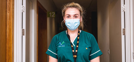 Nurse wearing a Iaith Gwaith lanyard  