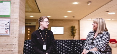 2 people having a discussion whilst sat on a sofa 